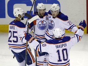 Edmonton Oilers' Taylor Hall (4) is hugged by teammates after scoring against the San Jose Sharks during the first period of an NHL hockey game Thursday, March 24, 2016, in San Jose, Calif. (AP Photo/Marcio Jose Sanchez) ORG XMIT: SJA110