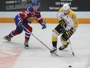 Brandon Wheat Kings' Tim McGauley skates through centre ice as Edmonton Oil Kings' Dario Meyer ties to poke check the puck away during Game 2 of their WHL playoff series at Westman Place in Brandon, Man., on March 25, 2016.