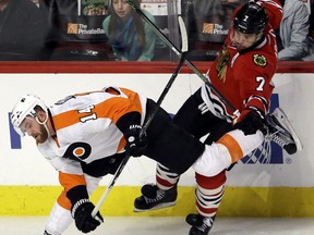Chicago Blackhawks defenseman Brent Seabrook, right, is hit by Philadelphia Flyers center Sean Couturier during the third period of an NHL hockey game, Wednesday, March 16, 2016, in Chicago. The Flyers won 3-2.