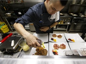 Executive Chef Phan Au prepares his signature Fried Chicken and Foie-ffles dish in the kitchen at Cured, 2307 Ellwood Drive.