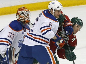 Edmonton Oilers goalie Cam Talbot, left, looks on as teammate Adam Pardy keeps Minnesota Wild's Zach Parise at bay in the first period of an NHL hockey game Thursday, March 10, 2016, in St. Paul, Minn.