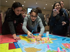 Students stick their names on their home countries during the ESL culture carnival at NorQuest College in Edmonton on Tuesday.