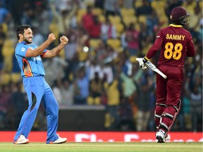 Afghanistan bowler Gulbadin Naib (L) celebrates after taking the wicket of West Indies's batsman Darren Sammy during the World T20 cricket tournament match between West Indies and Afghanistan at The Vidarbha Cricket Association Stadium in Nagpur on March 27, 2016.