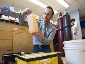 University of Alberta assistant professor Daniel Alessi examines flowback water in his lab. U of A researchers are looking for ways to make fracking more environmentally friendly.