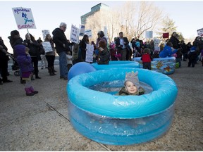 Children sit in birthing pools at a rally organized by the Association for Safe Alternatives in Childbirth, outside the Alberta legislature on March 9, 2016, in Edmonton. The group is  lobbying for a change in the funding of Alberta's midwife program.