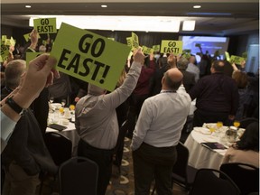 Delegates at the AUMA meeting on March 9, 2016, in Edmonton, raise cards in support of the Energy East pipeline.