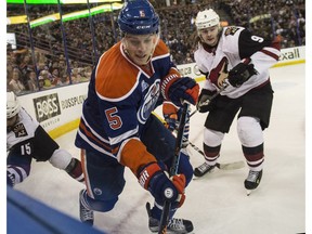 EDMONTON, AB. MARCH 11, 2016 - Mark Fayne of the Edmonton Oilers, moves the puck from the corner while being watched by Viktor Tikhonov of the Arizona Coyotes at Rexall Place in Edmonton.   Shaughn Butts / POSTMEDIA NEWS NETWORK
