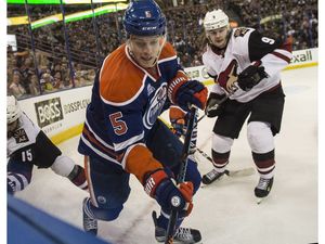 EDMONTON, AB. MARCH 11, 2016 - Mark Fayne of the Edmonton Oilers, moves the puck from the corner while being watched by Viktor Tikhonov of the Arizona Coyotes at Rexall Place in Edmonton. Shaughn Butts / POSTMEDIA NEWS NETWORK