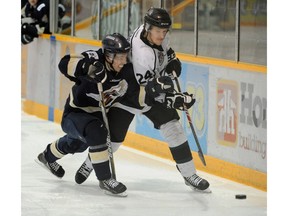 Colten Meaver of the Sherwood Park Crusaders tries to get past Cameron Hughes of the Spruce Grove Saints in Alberta Junior Hockey League playoffs at Sherwood Park Arena.