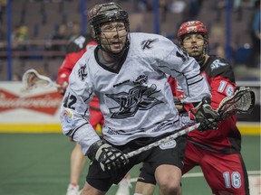 Mark Matthews of the National Lacrosse League Edmonton Rush runs towards a loose ball with Mike Carnegie of the Calgary Roughnecks at Rexall Place in Edmonton.