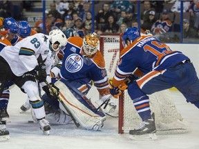 Cam Talbot  of the Edmonton Oilers, is unable to freeze the loose puck but Logan Couture of the San Jose Sharks (not seen) is able to score his first of two goals in the first period at Rexall Place in Edmonton.