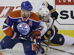 Edmonton Oilers winger Taylor Hall (left) and Nashville Predators winger Filip Forsberg battle for the puck during first period NHL hockey game action in Edmonton on Monday March 14, 2016.