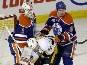 Nashville Predators winger Victor Arvidsson (middle) is caught between Edmonton Oilers goalie Laurent Brossoit (left) and Oilers defenceman Griffin Reinhart (right) during second period NHL hockey game action in Edmonton on Monday March 14, 2016.