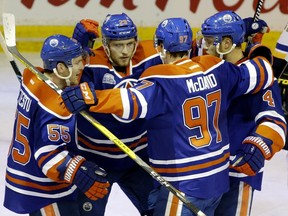 Oilers centres (L-R) Mark Letestu, Leon Draisaitl, and Connor McDavid celebrate a powerplay goal with some other guy.