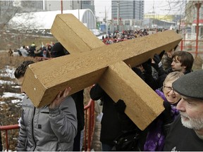 Hundreds of people walked for two kilometers through downtown Edmonton carrying a wooden cross at the 36th Annual Good Friday Outdoor Way of the Cross walk on Friday March 25, 2016.
