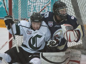 Spruce Grove Saints goalie Brett Zarowny makes a save with Bryar Ortynski on him in the AJHL North Division semifinal Game 4 between the Sherwood Park Crusaders and the Spruce Grove Saints at the Sherwood Park Arena, March 17, 2015.