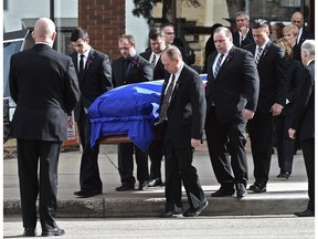 Pallbearers carry the casket of former Premier Don Getty draped in the Alberta flag to the hearse as family members follow after his state funeral at All Saints Anglican Cathedral in downtown Edmonton, March 5, 2016.