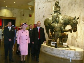 Queen Elizabeth II walks with Alberta officials past the homesteader statue at Royal Alberta Museum in May 2005 when the building received the "royal" moniker.