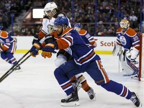 Edmonton's Darnell Nurse (25) battles Anaheim's Korbinian Holzer (5) during the first period of an NHL game between the Edmonton Oilers and the Anaheim Ducks at Rexall Place in Edmonton, Alta., on Monday March 28, 2016.