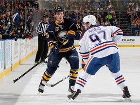 Jack Eichel #15 of the Buffalo Sabres passes the puck past Connor McDavid #97 of the Edmonton Oilers at First Niagara Center on March 1, 2016 in Buffalo, New York.