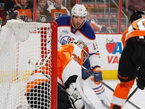 Patrick Maroon #19 of the Edmonton Oilers slides the puck through the crease past Michal Neuvirth #30 of the Philadelphia Flyers during the first period at the Wells Fargo Center on March 3, 2016 in Philadelphia, Pennsylvania.