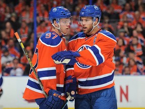 Connor McDavid #97 and Taylor Hall #4 of the Edmonton Oilers discuss play during a game against the St. Louis Blues on October 15, 2015 at Rexall Place in Edmonton.