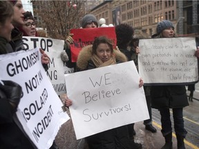 Protester hold signs outside of the Toronto courthouse as they await a verdict in the Jian Ghomeshi sexual assault trial, on Thursday, March 24, 2016.
