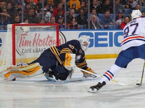 Connor McDavid #97 of the Edmonton Oilers avoids a poke check from Robin Lehner #40 of the Buffalo Sabres before scoring a first period goal during an NHL game on March 1, 2016 at the First Niagara Center in Buffalo, New York.