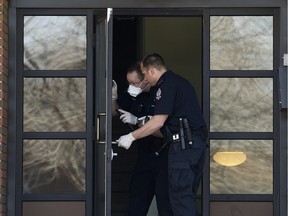 Police officers dust for prints as Edmonton Police continue to investigate a suspicious death at 11455 - 132 St., in Edmonton Alta. on Monday March 28, 2016. Edmonton Police are currently treating it as a homicide.