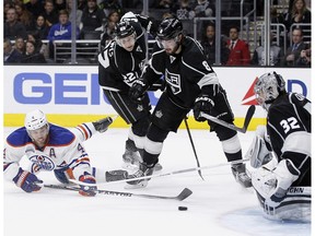 Edmonton Oilers left wing Taylor Hall (4) sweeps a shot at Los Angeles Kings goalie Jonathan Quick (32) with center Trevor Lewis (22) and defenseman Drew Doughty (8) looking on during the third period of an NHL hockey game in Los Angeles, Saturday, March 26, 2016. The Kings won 6-4.
