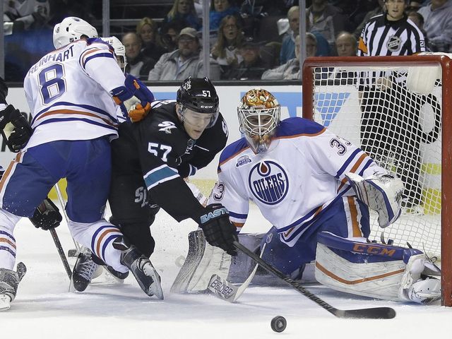 San Jose Sharks' Tommy Wingels (57) collides with Edmonton Oilers' Griffin Reinhart (8) and Oilers goalie Cam Talbot (33) during the first period of an NHL hockey game Thursday, March 24, 2016, in San Jose, Calif.