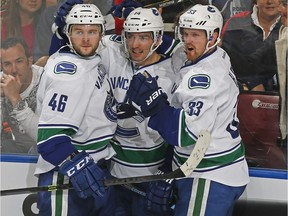 Alex Burrows #14 is congratulated by Nicklas Jensen #46 and Henrik Sedin #33 of the Vancouver Canucks after scoring a third period goal against the Florida Panthers at the BB&T Center on March 16, 2014 in Sunrise, Florida. Vancouver defeated the Panthers 4-3 in a shootout.