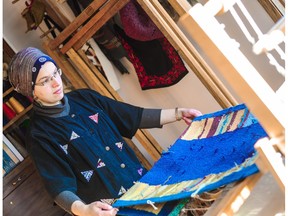 Weaver Noor Iqbal works on the prayer rug that she and Metis designer Kit Walton collaborated on with the Islamic Family and Social Services Association. The rug contains elements meant to represent Edmonton and tell the story of the city's Muslim community throughout its history and the present day.