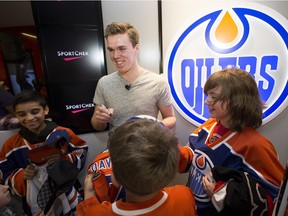 The Edmonton Oilers' Connor McDavid signs autographs for minor jockey players from the KC Renegades during a surprise visit with the team at the West Edmonton Mall Sport Chek in Edmonton on Monday, April 11, 2016.