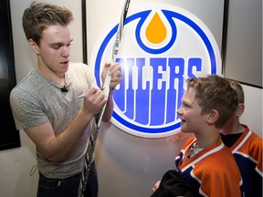 The Edmonton Oilers' Connor McDavid signs autographs for minor jockey players from the St. Charles Bulldogs and St. Charles Renegades during a surprise visit with the teams at the West Edmonton Mall Sport Chek, in Edmonton Alta. on Monday April 11, 2016.