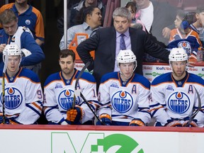 Edmonton Oilers head coach Todd McLellan, back, stands on the bench behind Edmonton Oilers' Connor McDavid, from left, Jordan Eberle, Ryan Nugent-Hopkins and Taylor Hall during the second period of an NHL hockey game against the Vancouver Canucks in Vancouver, B.C., on April 9, 2016.