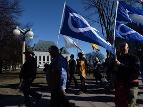 David Chartrand, president of the Manitoba Métis Federation, middle, carries the Métis flag as he and fellow Métis Federation leaders and delegates march to the Supreme Court of Canada in Ottawa on Thursday.