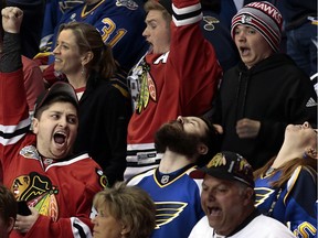 A Chicago Blackhawks fan celebrates after a goal by St. Louis Blues Vladimir Tarasenko was waved off on an offsides call, to the dismay of Blues fans, in the third period of Game 2 of a first-round series in the NHL hockey Stanley Cup playoffs, Friday, April 15, 2016, in St. Louis. The Blackhawks won 3-2 to even the series at a game apiece. (Robert Cohen/St. Louis Post-Dispatch via AP) ORG XMIT: MOSTP332