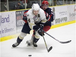 The Spruce Grove Saints' Connor James (4) battles the Brooks Bandits' Tristan Thompson (4) during first period AJHL action at Grant Fuhr Arena, in Spruce Grove Alta. on Saturday April 16, 2016. This was game 2 of the 2016 Alberta Junior Hockey League Gas Drive Cup. Photo by David Bloom