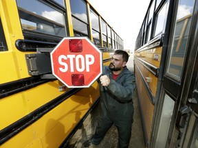 Mechanic Kyle Bahr works on a school bus at the south Edmonton Cunningham Transport yard on April 27, 2016. Edmonton Public Schools hasn't yet calculated the potential cost of a carbon tax on busing.