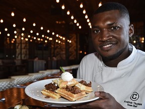 Sous Chef Rodrick Thomas holding the Belgian waffles made from scratch at Central Social Hall.