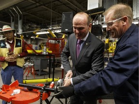 Dan McDonough (right) with Alberta Pipe Trades College guides MP Randy Boissonnault during a pipe fitting demonstration after the announcement of $1,069,938 in funding to support the expansion of the pre-apprenticeship training program for Indigenous adult learners on Monday April 25, 2016.