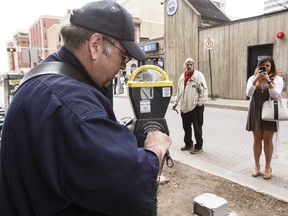 Parking meter serviceman Don Striker removes a coin meter Wednesday on Rice Howard Way.