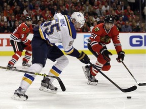 St. Louis Blues defenseman Colton Parayko (55) works for the puck against Chicago Blackhawks defenseman Trevor van Riemsdyk (57) during the first period in Game 4 of an NHL hockey first-round Stanley Cup playoff series Tuesday, April 19, 2016, in Chicago.