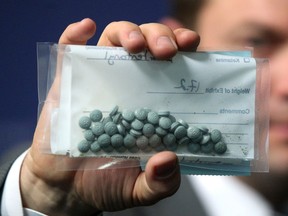 Calgary Police Service Staff Sgt. Martin Schiavetta holds up an evidence bag with seized Fentanyl tablets during a 2015 press conference to raise awareness around the street drug.