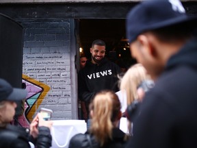 Toronto rapper Drake smiles as he hands out T-shirts at a pop up shop to promote his upcoming album in Toronto.