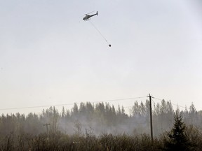 Two helicopters and 25 firefighters fight a brush fire last week near Duffield, a hamlet about 65 km west of Edmonton.