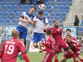 EDMONTON AB. APRIL 23, 2016 - Albert Watson and Jake Keegan of FC Edmonton attempt the header from a corner kick against the Ottawa Fury at Clarke Field in Edmonton.   Shaughn Butts / POSTMEDIA NEWS NETWORK