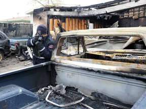 A fire investigator photographs the scene of an overnight fire at 9620 144 Ave. in Edmonton April 24, 2016.