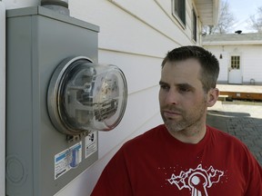 Mike Thomas beside his power meter at his home in northeast Edmonton. He's concerned that the contractor for Epcor is not using electricians to replace existing meters with advanced devices.